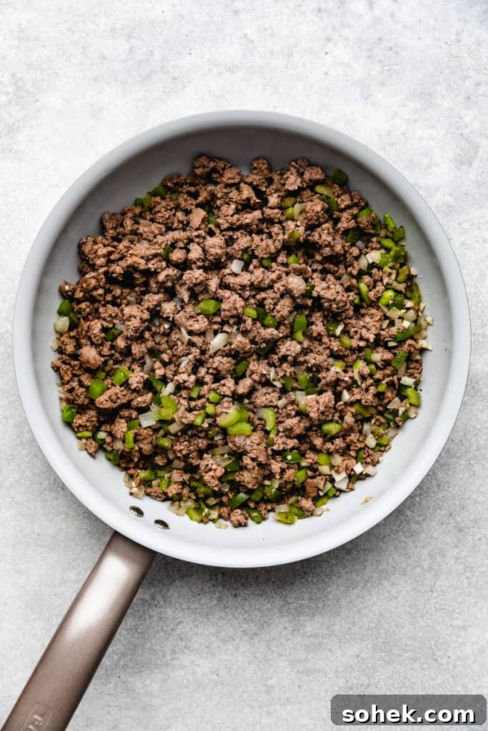 Cheesy Hamburger Rice Casserole Recipe for Comforting Weeknight Meals 3 Cooked ground beef and onions in a skillet.