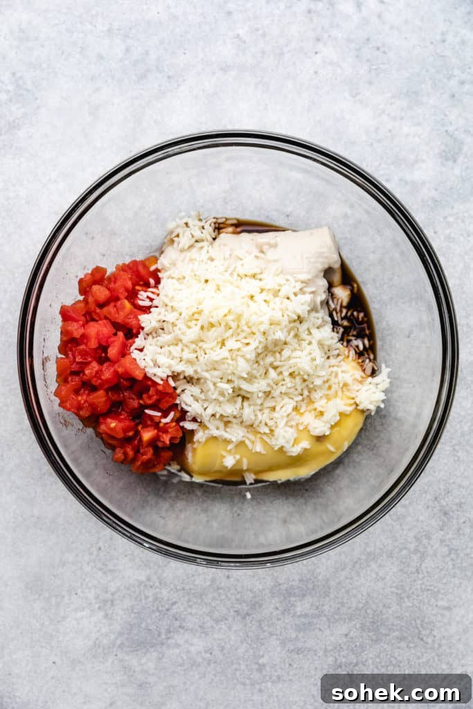 Cheesy Hamburger Rice Casserole Recipe for Comforting Weeknight Meals 5 Cream of soups, rice, diced tomatoes, and seasonings in a bowl.