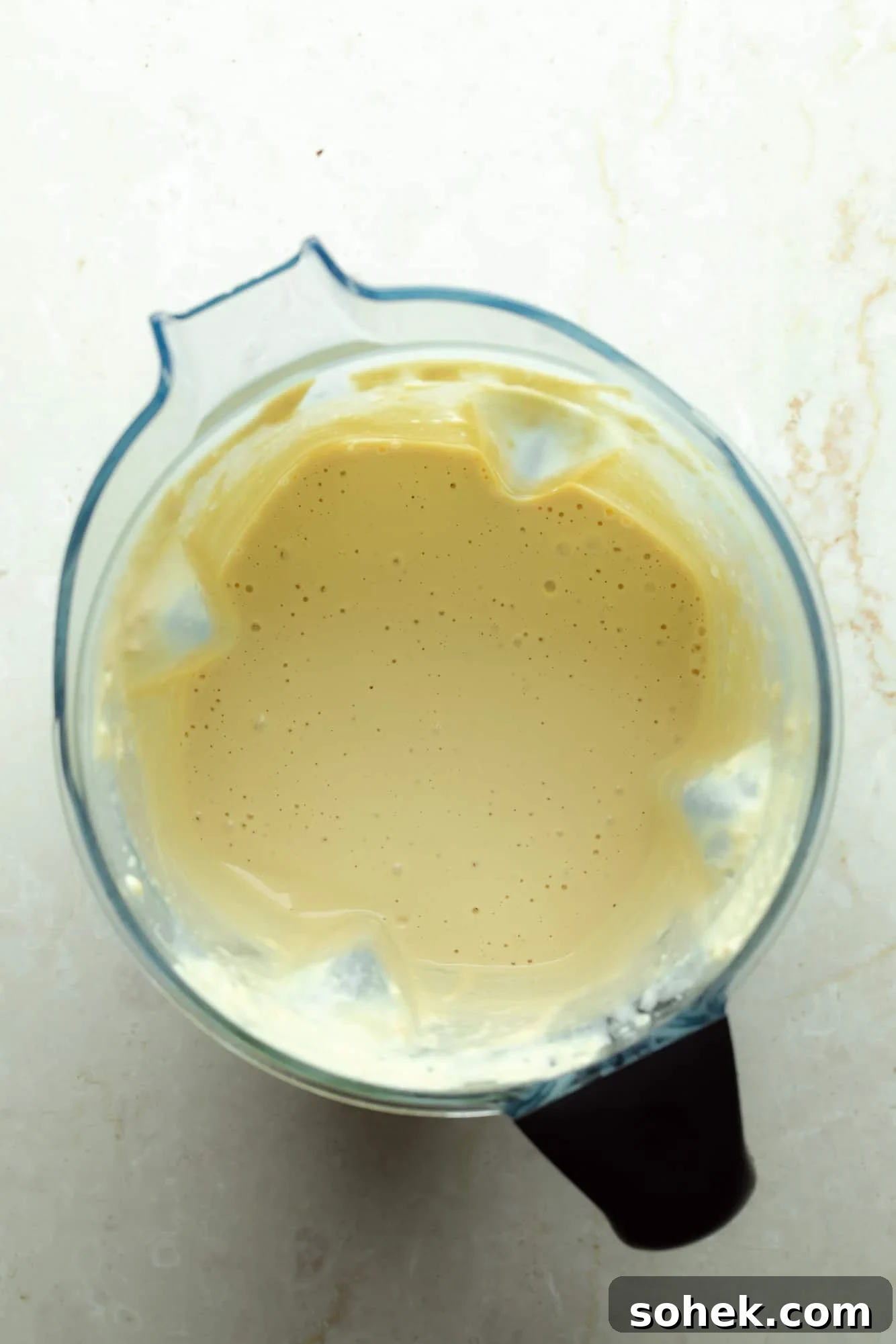 High-Protein Sharp White Mac and Cheese with Broccoli 5 overhead view of a smooth white vegan cheese sauce in a blender.