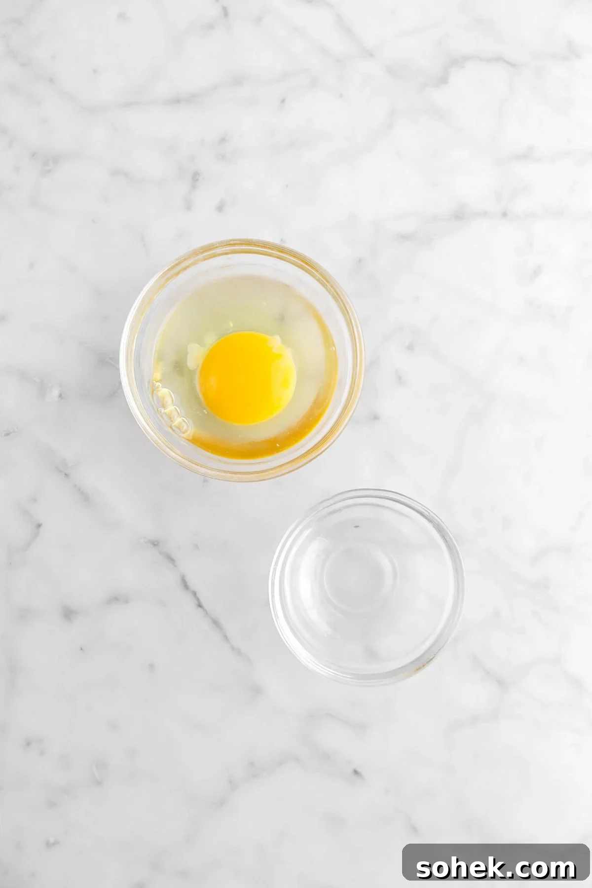 egg and water in two bowls on marble surface