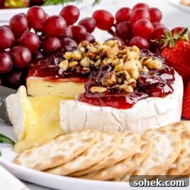 Baked Brie with Jam: Gooey Appetizer Recipe for Entertaining 9 close shot of Baked Brie topped with Jam and walnuts served with crackers