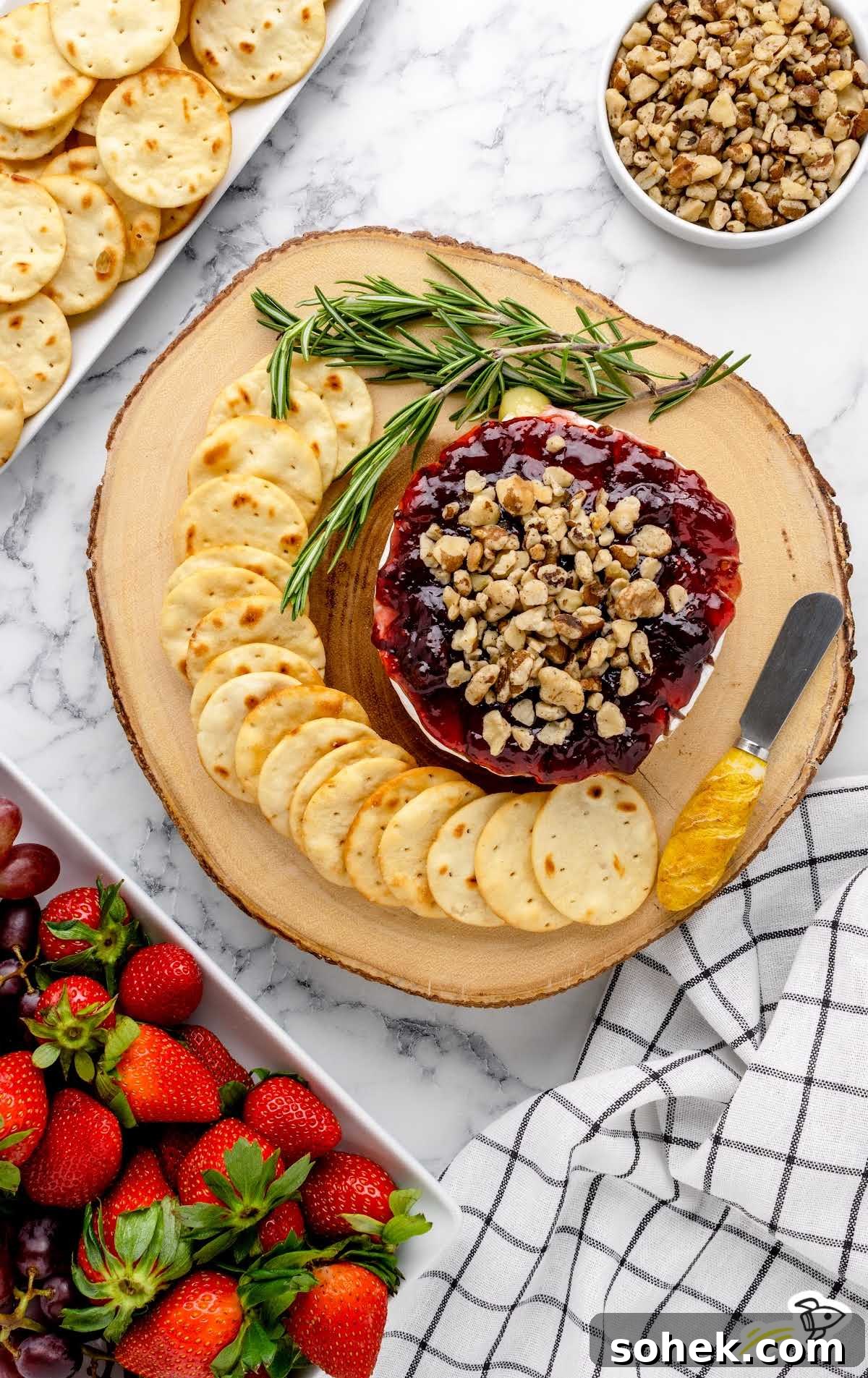 Baked Brie with Jam: Gooey Appetizer Recipe for Entertaining 8 overhead shot of Baked Brie topped with Jam and walnuts served with crackers