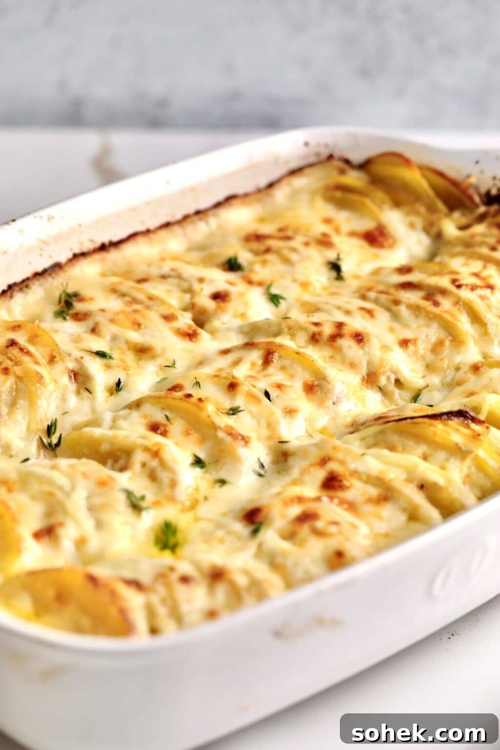 Potatoes au gratin in a white baking dish.
