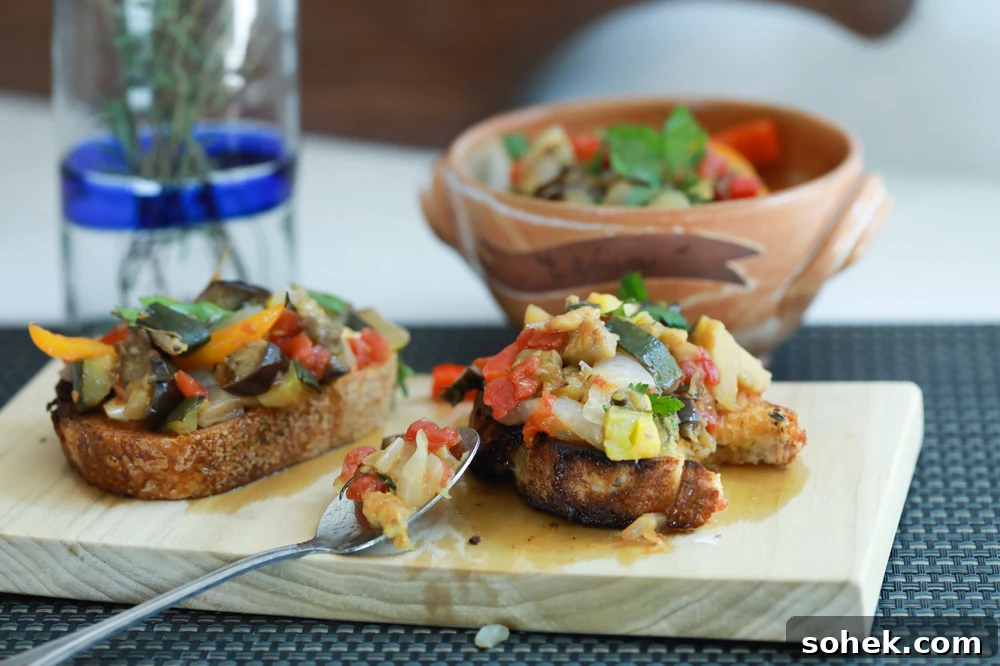 Ratatouille tartine on a wooden board with a spoon.
