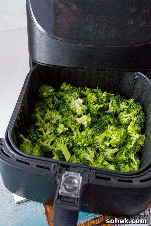 Crispy Air Fryer Roasted Broccoli Recipe 6 broccoli in the basket of the air fryer ready to cook for Air Fryer Roasted Broccoli