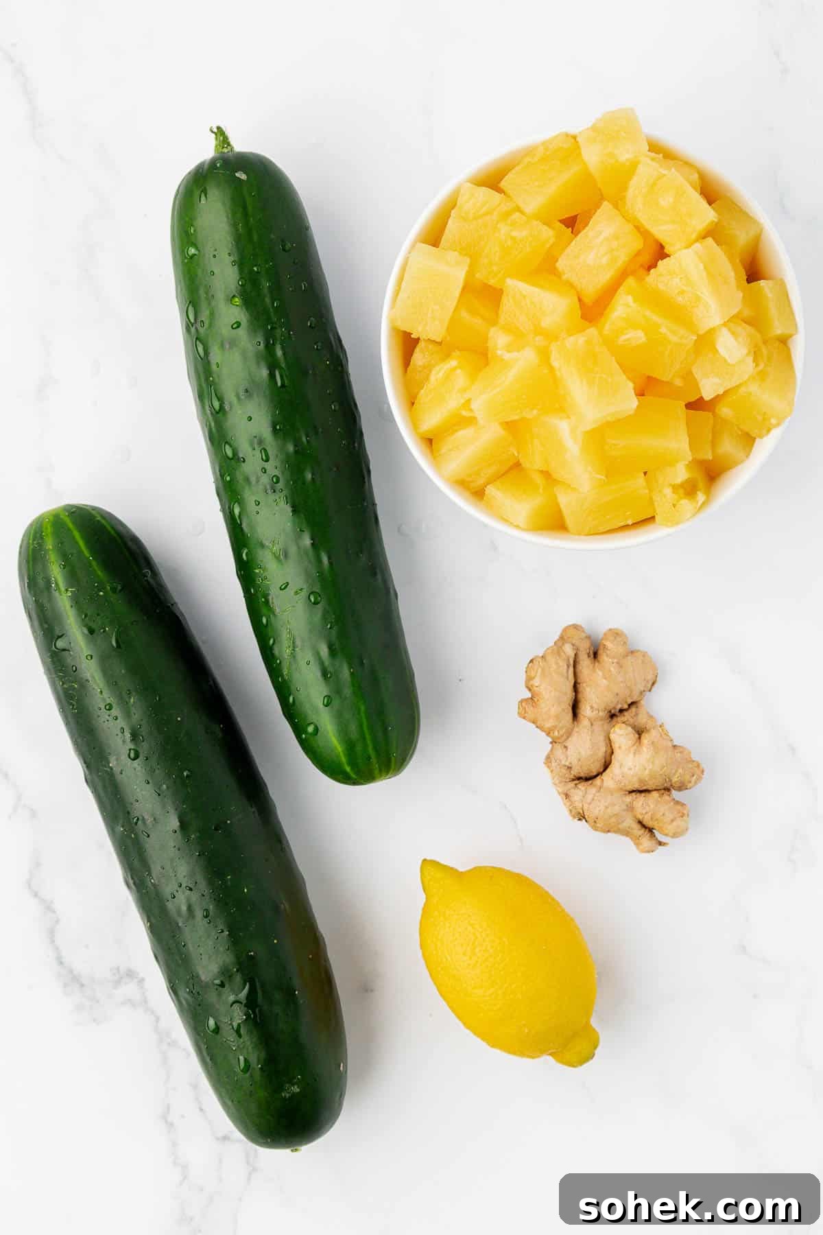 two cucumbers, lemon, pineapple chunks, and ginger