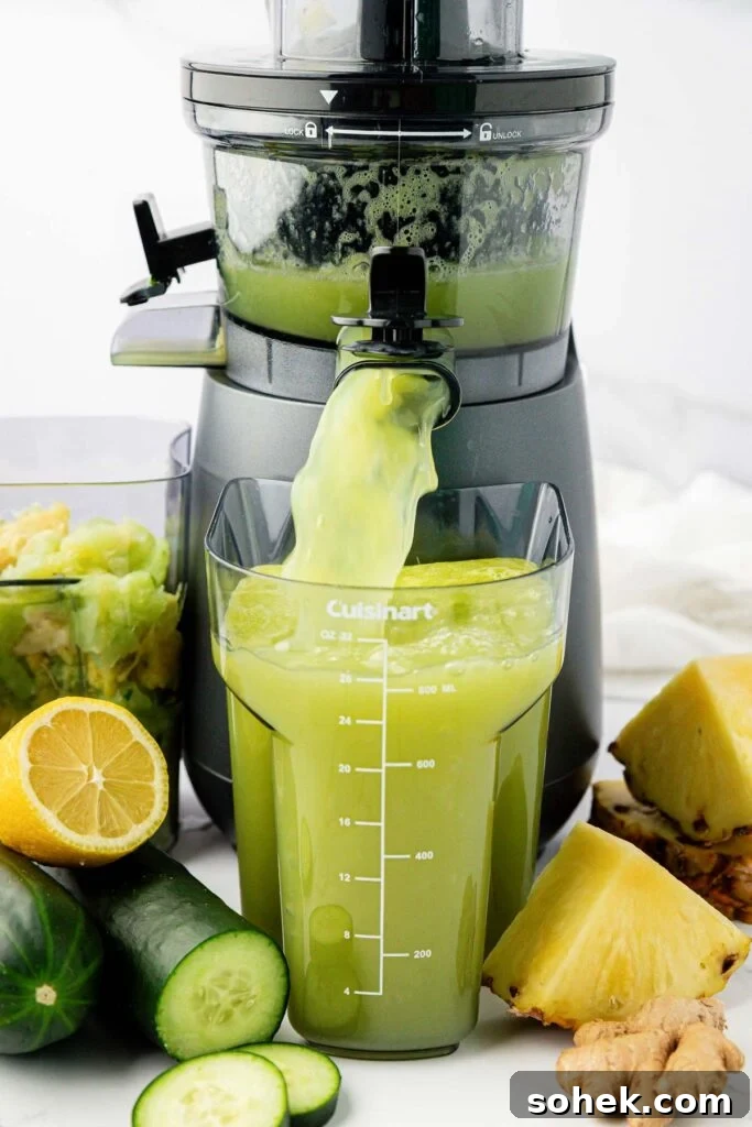 pineapple cucumber juice coming out of a juicer