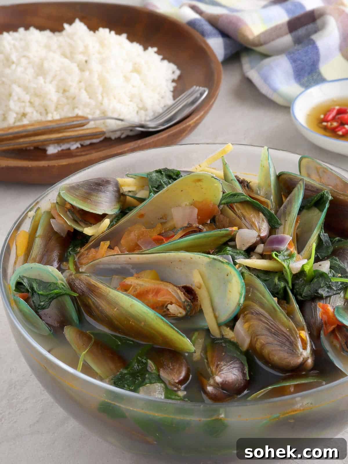 Mussel Soup (Sinabawang Tahong): Filipino Seafood Broth Recipe 5 mussel soup in a bowl with a plate of steamed rice in the background.