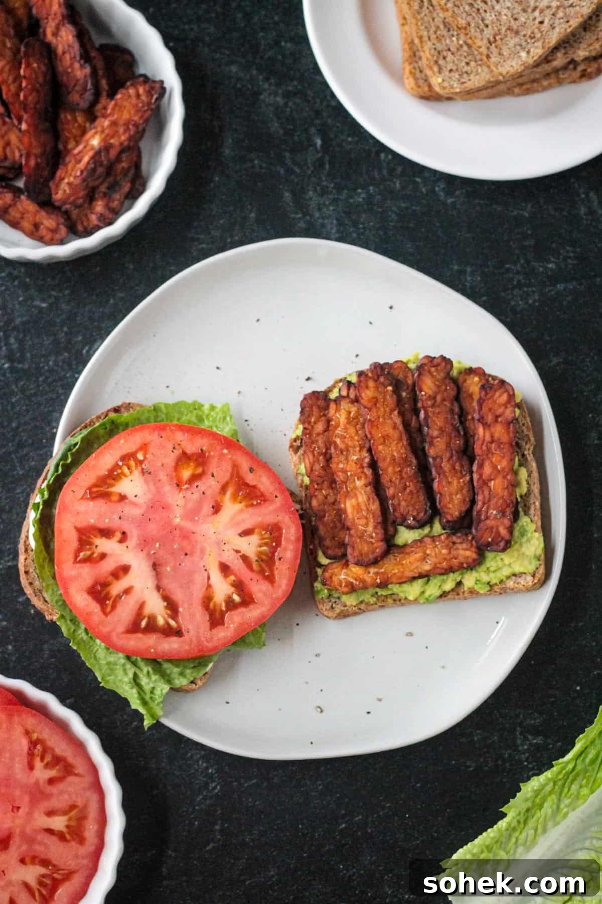 Crispy Vegan BLT Sandwich with Smoky Tempeh Bacon 4 Tempeh bacon on an open face sandwich.