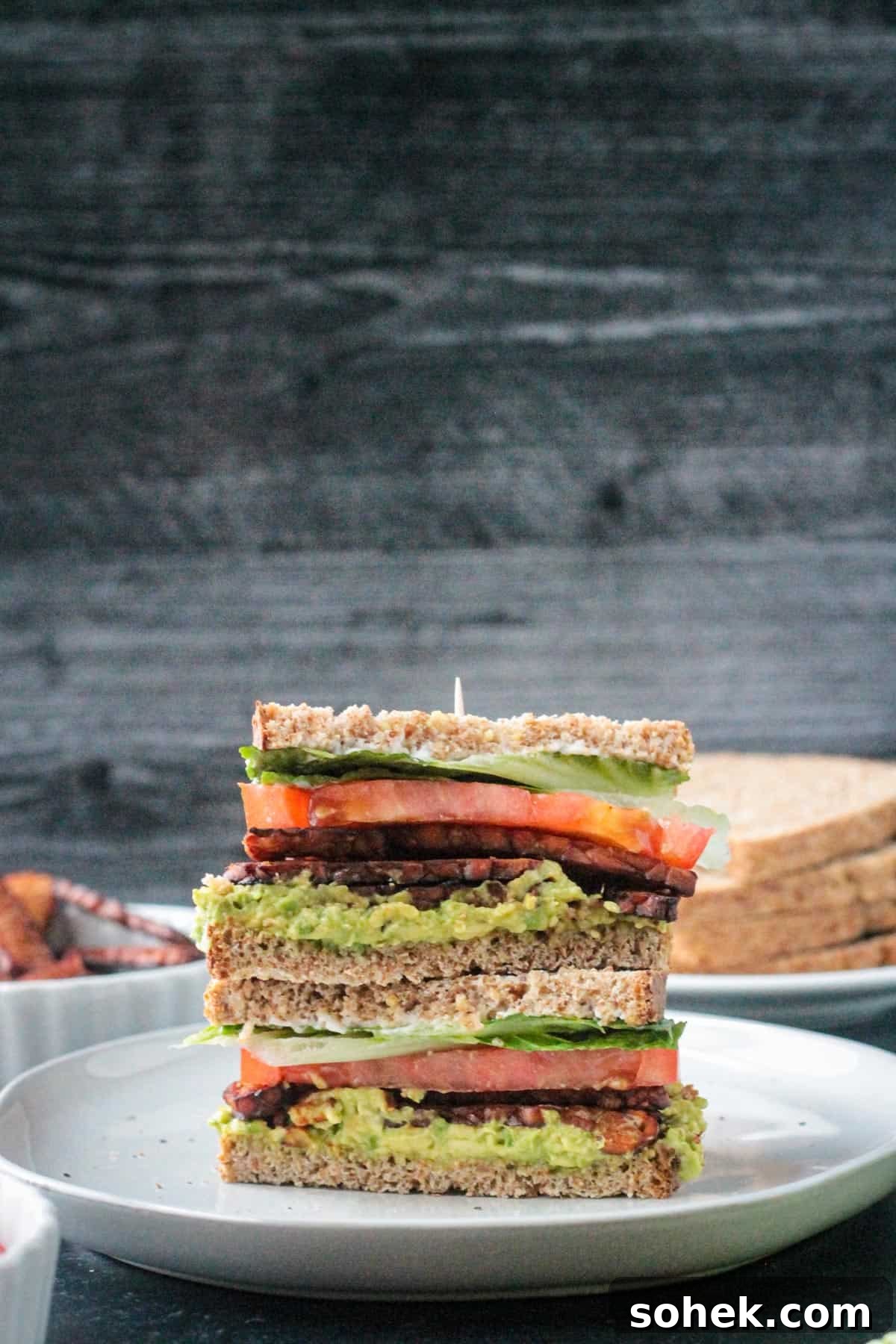 Crispy Vegan BLT Sandwich with Smoky Tempeh Bacon 5 Two halves of a vegan blt sandwich stacked on top of each other.