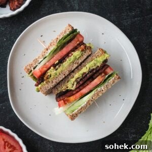 Crispy Vegan BLT Sandwich with Smoky Tempeh Bacon 6 Two halves of a vegan blt sandwich on a plate.