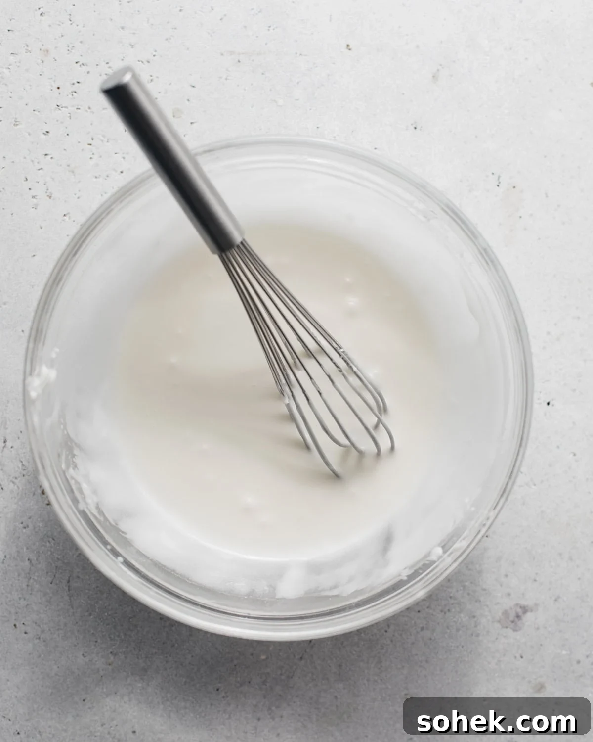 key lime glaze in a bowl with a whisk.
