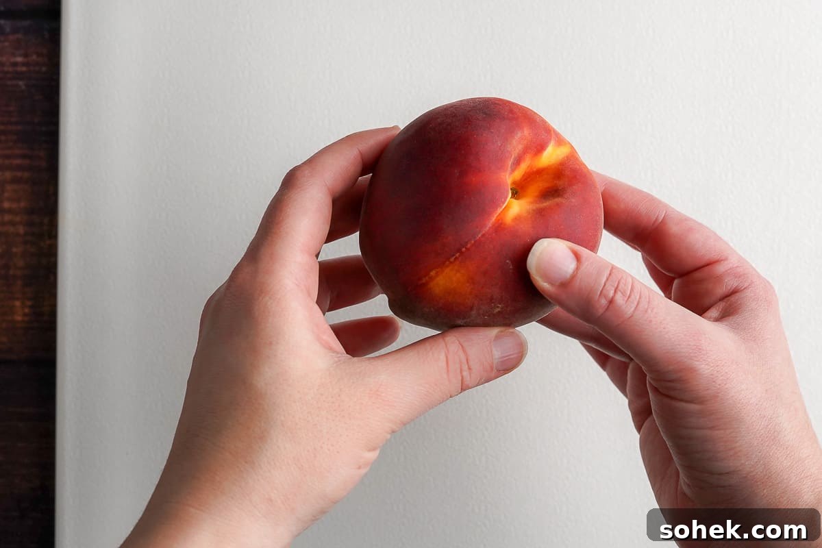 Two hands holding a ripe peach