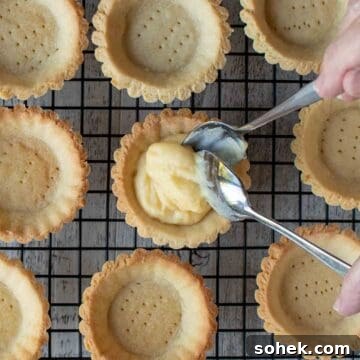 Mini Fresh Fruit Tarts Recipe: Bite-Sized Dessert for Parties 12 Pastry cream being spooned into tartlet bases.