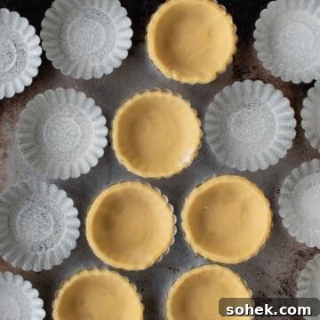 Mini Fresh Fruit Tarts Recipe: Bite-Sized Dessert for Parties 10 Overhead view of mini tartlet pans some lined with pastry.