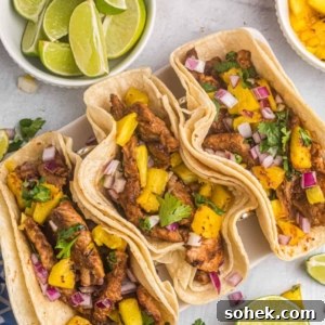 Three tacos are placed next to a few different garnishes.