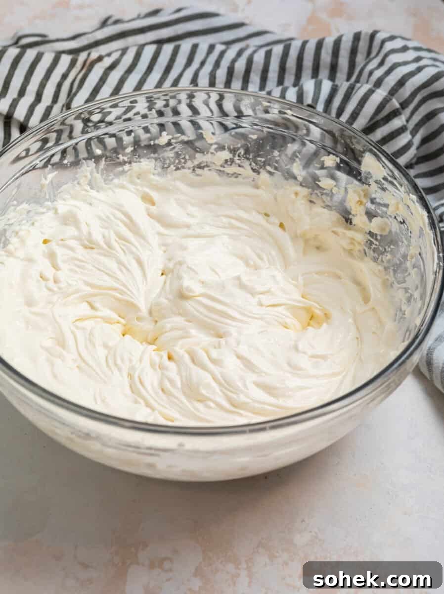 Spinach and Artichoke Chicken Casserole Recipe for Family Meals 3 Cream cheese and cream mixed in glass mixing bowl.