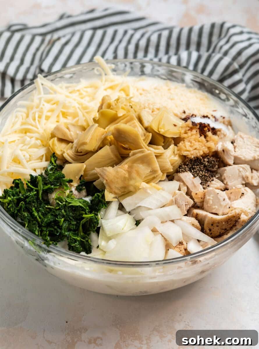 Spinach and Artichoke Chicken Casserole Recipe for Family Meals 4 Spinach, artichokes, chicken, onion, cheese and other ingredients in mixing bowl.