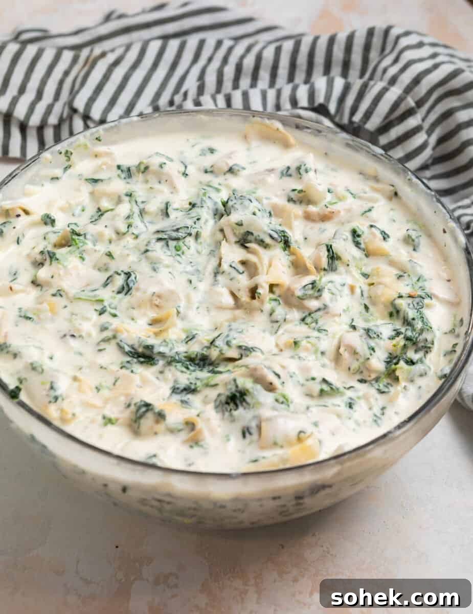 Spinach and Artichoke Chicken Casserole Recipe for Family Meals 5 Spinach artichoke chicken creamy mixture in glass mixing bowl.