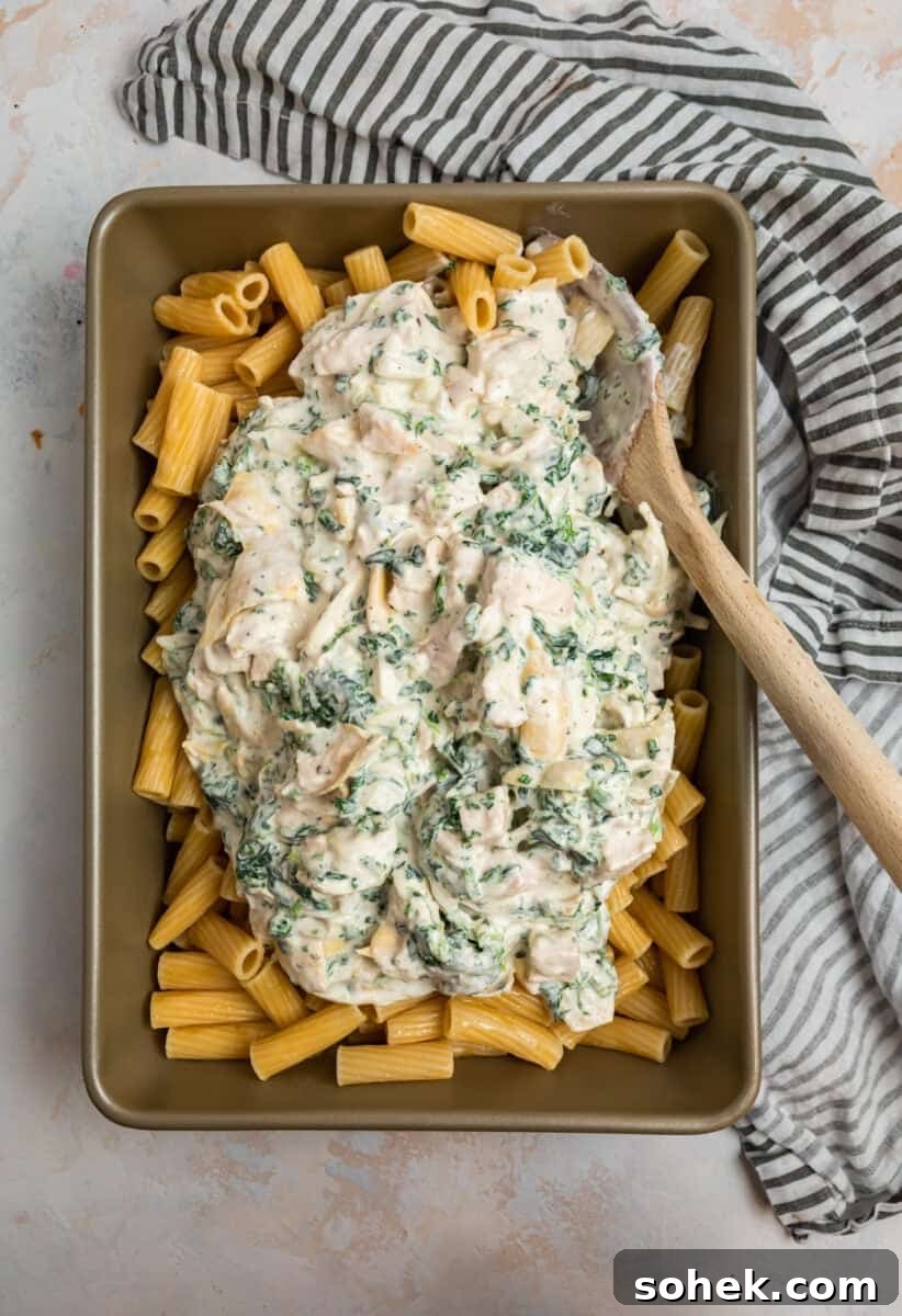 Spinach and Artichoke Chicken Casserole Recipe for Family Meals 7 Spinach artichoke and chicken mixture over past in pan.