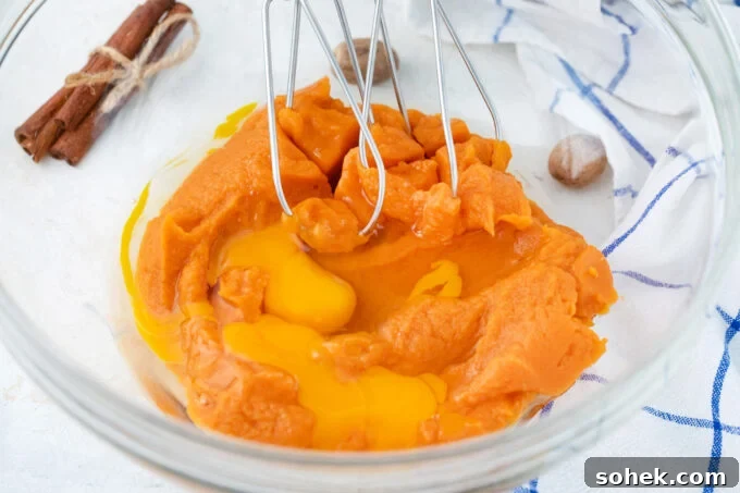 Creamy Sweet Potato Pie Cupcakes Recipe for Fall Desserts 5 Whisking sweet potato puree and eggs in a bowl.