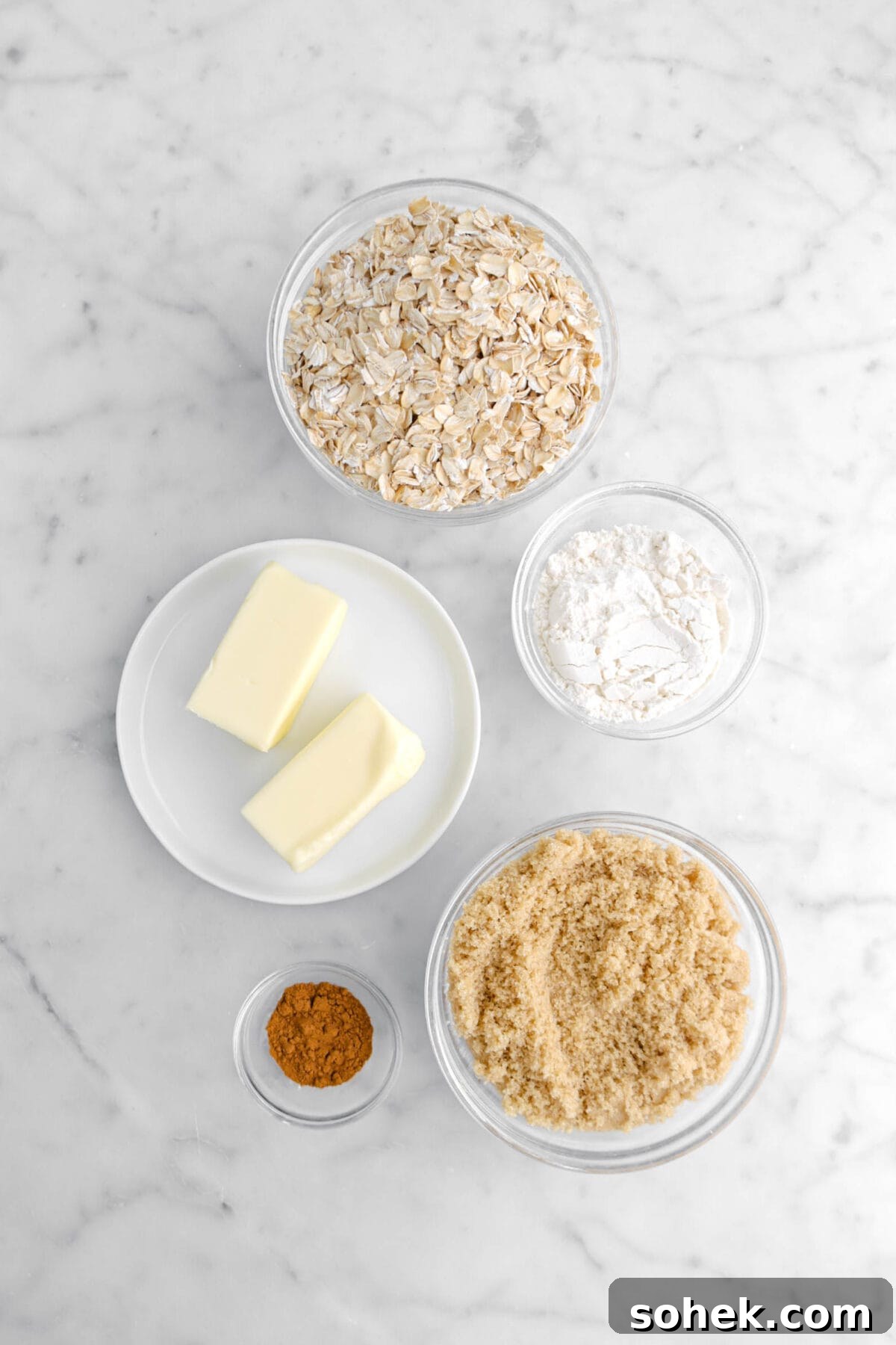 Apple Cranberry Crumble Pie Recipe with Buttery Oat Topping 7 oats, butter, flour, brown sugar, and cinnamon on marble surface.