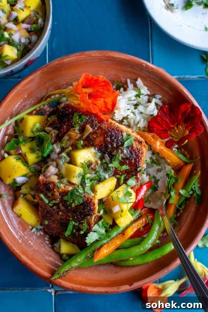 Crispy Salmon Rice Bowl with Fresh Mango Salsa 2 Crispy salmon rice bowls with mango salsa on a blue tile background.