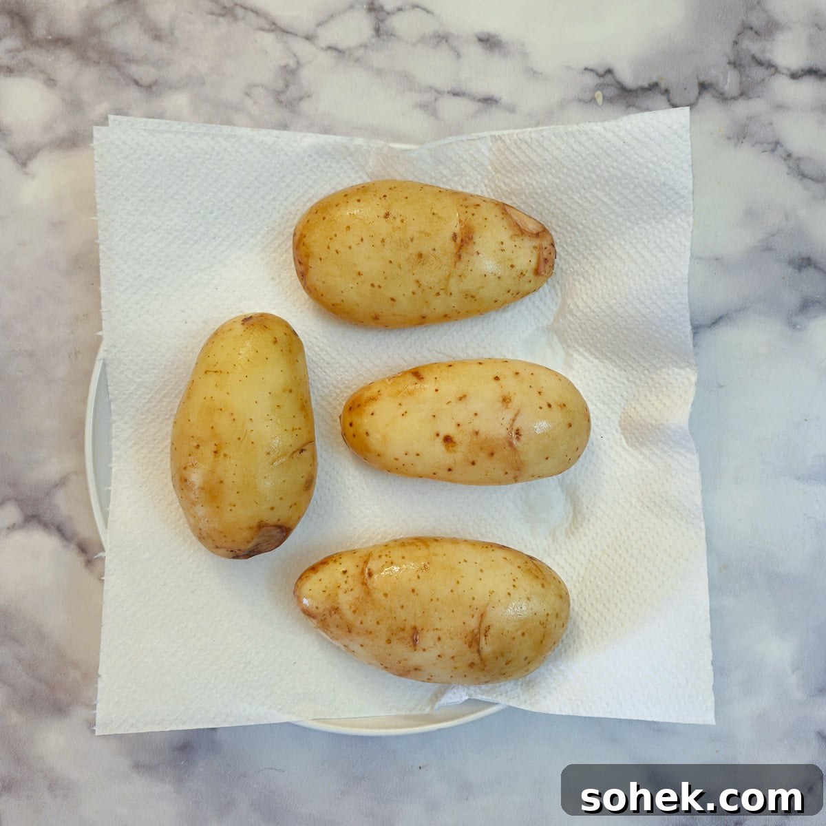 4 potatoes on a paper towel.