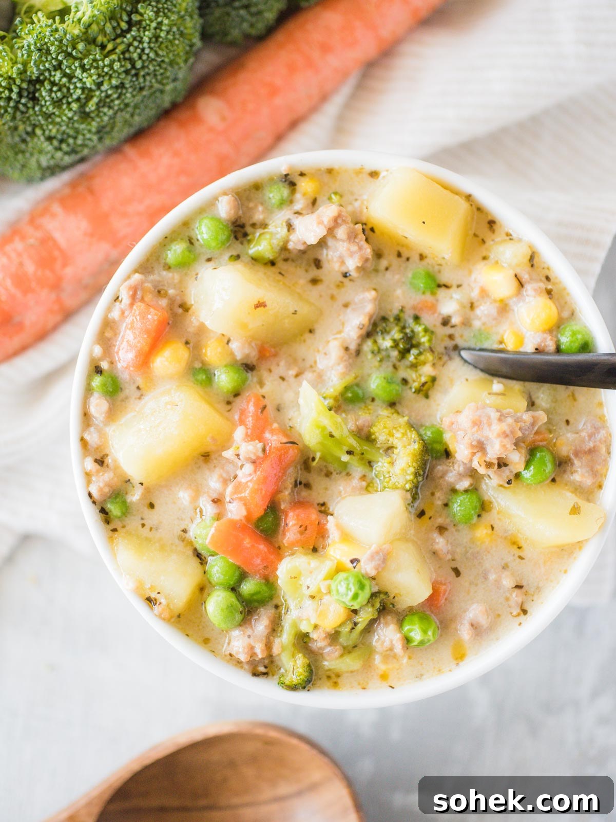 Hearty Italian Sausage and Potato Soup Recipe 2 a bowl of soup with a black spoon inside the bowl