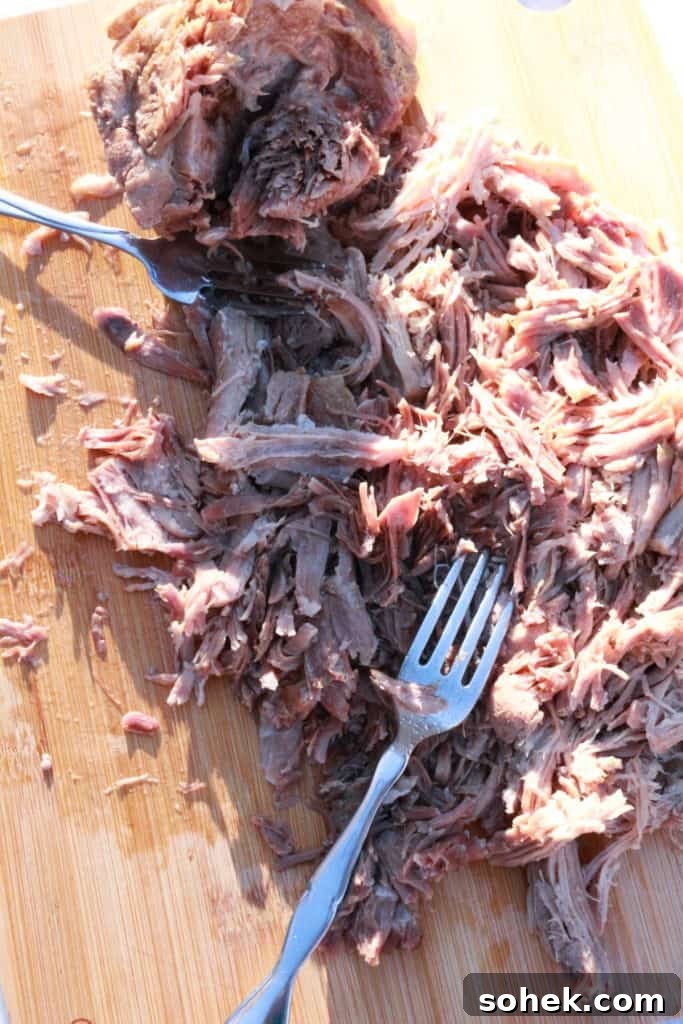 Authentic Mexican Shredded Pork (Carnitas) Recipe for Tacos 5 Shredding pork with forks