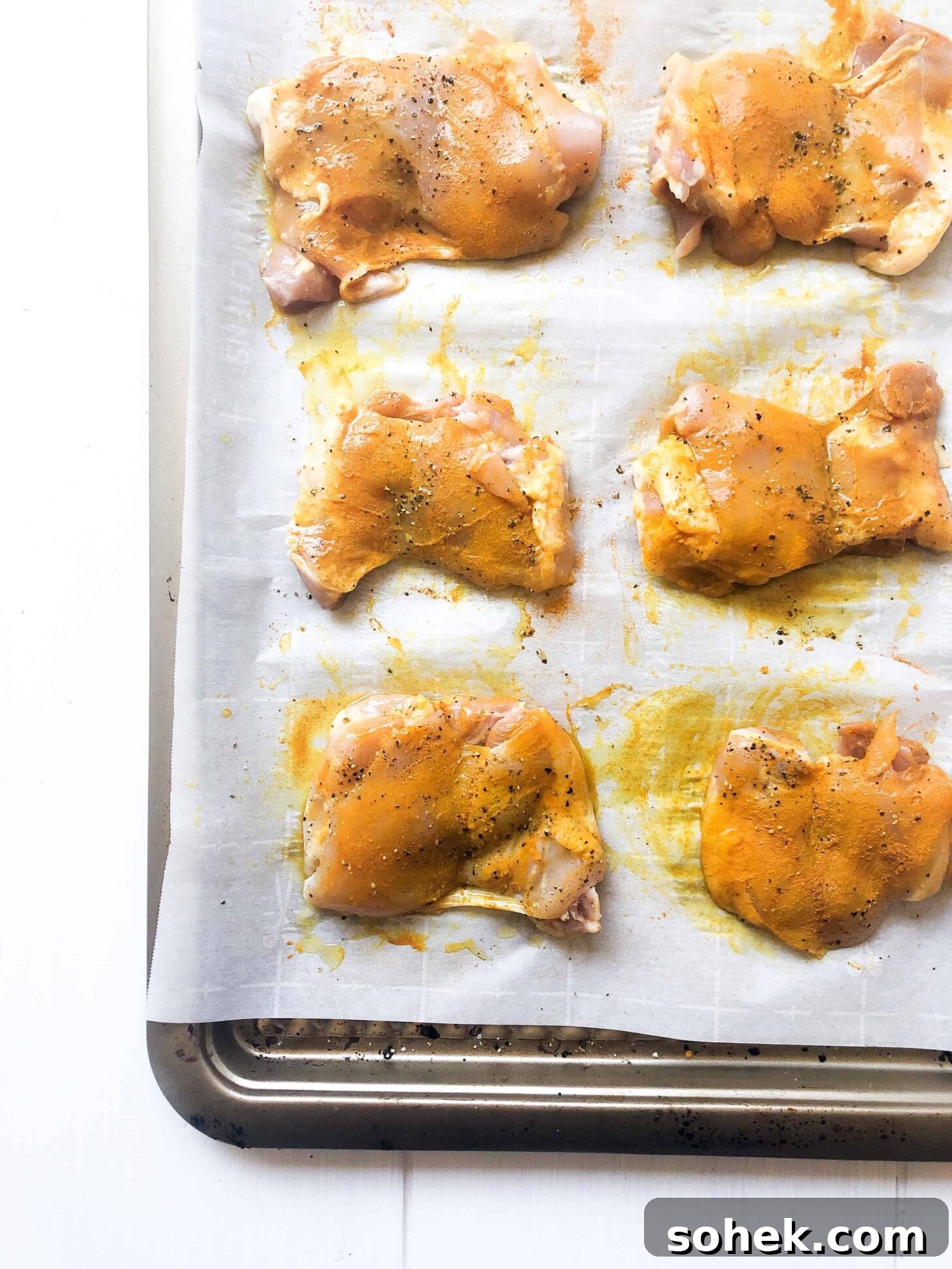 Turmeric-Grilled Chicken with Citrus Garlic Marinade 3 A sheet pan with six chicken thighs coated with turmeric and black pepper