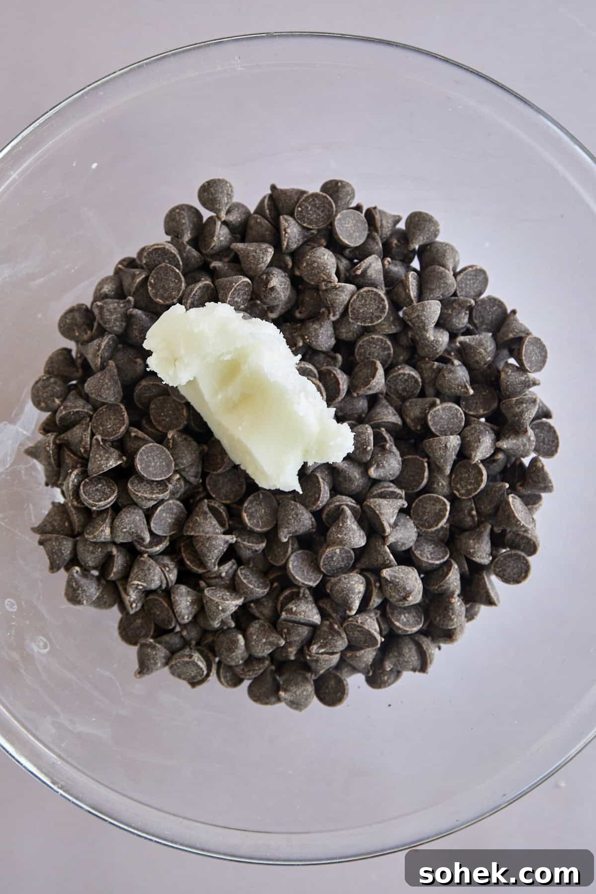 Viral Chocolate-Covered Strawberry Yogurt Clusters Recipe 3 A bowl of semi-sweet chocolate chips with coconut oil on top.