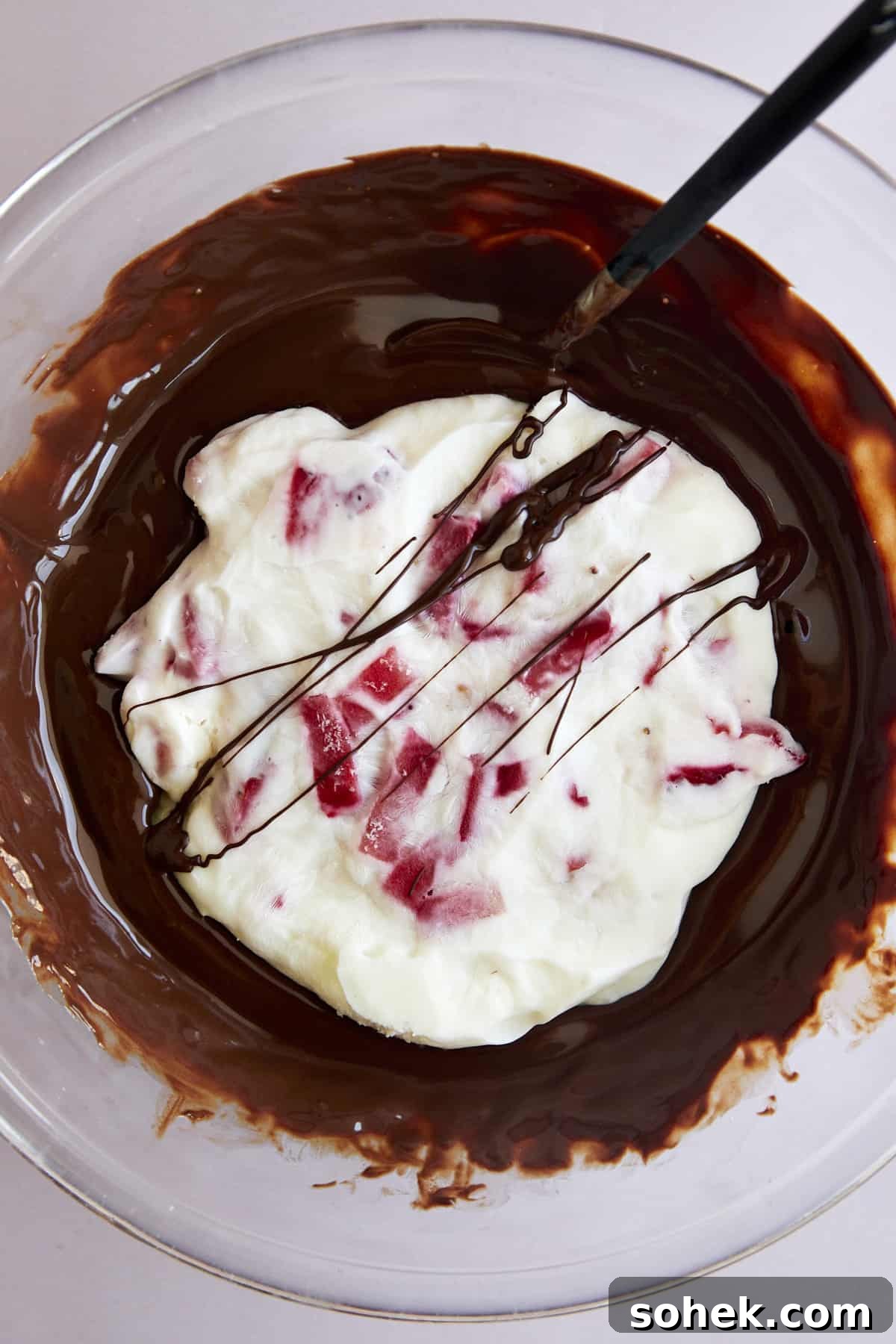 Viral Chocolate-Covered Strawberry Yogurt Clusters Recipe 5 Overhead image of a strawberry yogurt cluster in a bowl of melted chocolate.