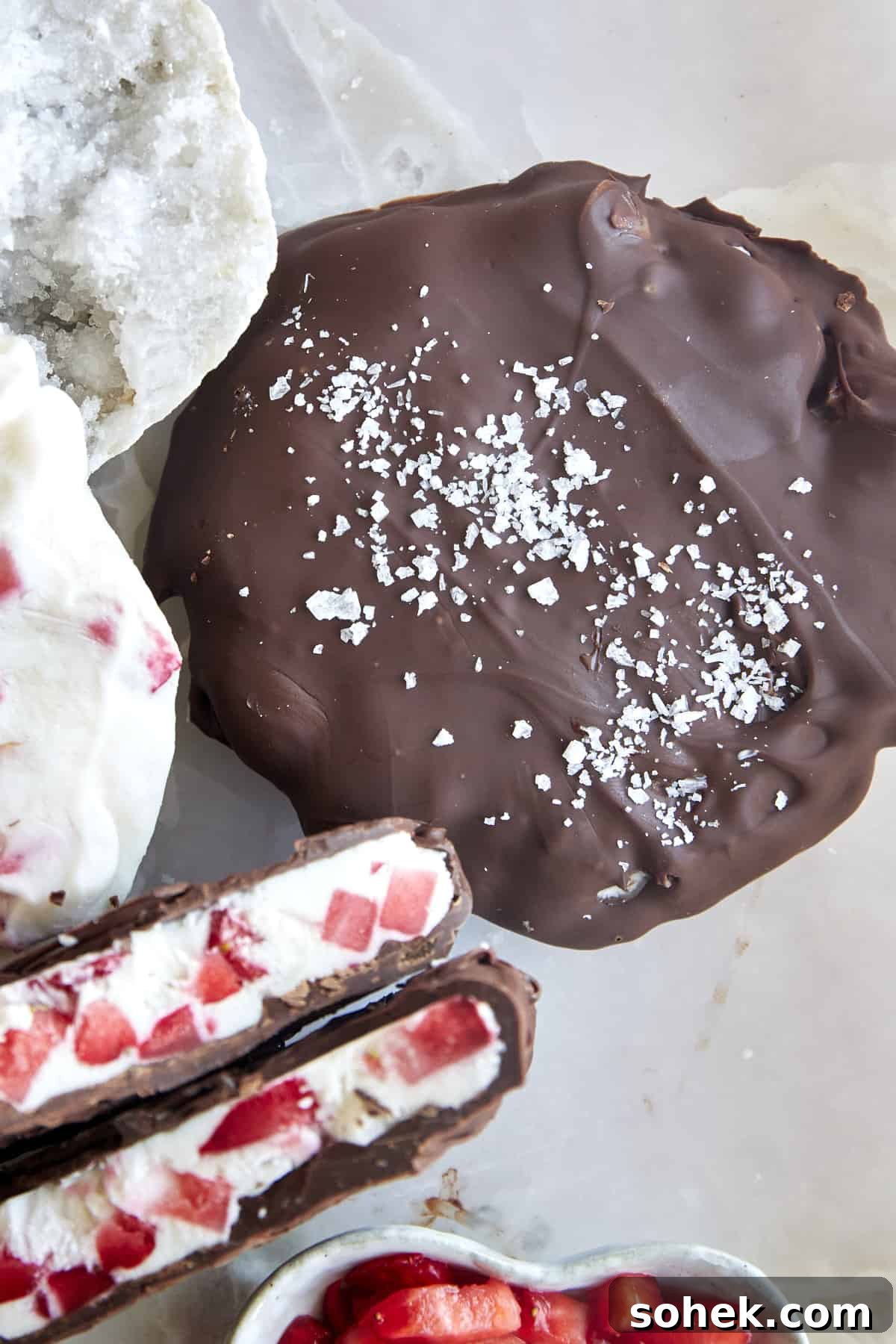 Viral Chocolate-Covered Strawberry Yogurt Clusters Recipe 6 Two chocolate strawberry yogurt clusters topped with salt with one split in half.