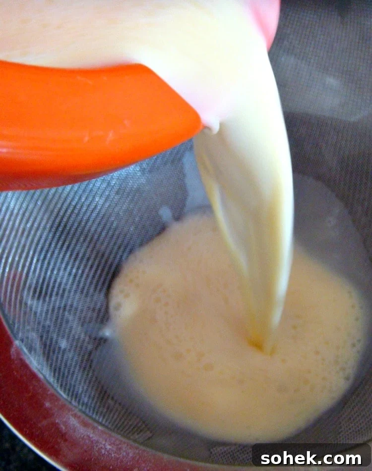 Gluten Free Egg Custard Tart. showing egg mixture being passed through a sieve