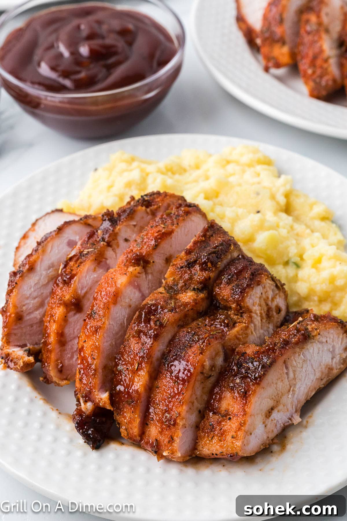 Juicy Grilled Turkey Tenderloin with Garlic Herb Marinade 7 Sliced Turkey Tenderloin on a plate with a side of cheesy rice casserole