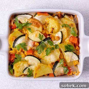 Zucchini Chicken and Potato Casserole Recipe for Weeknight Meals 2 Closeup overhead view of Zucchini Chicken and Potato Casserole in a white ceramic square baking dish on a white table