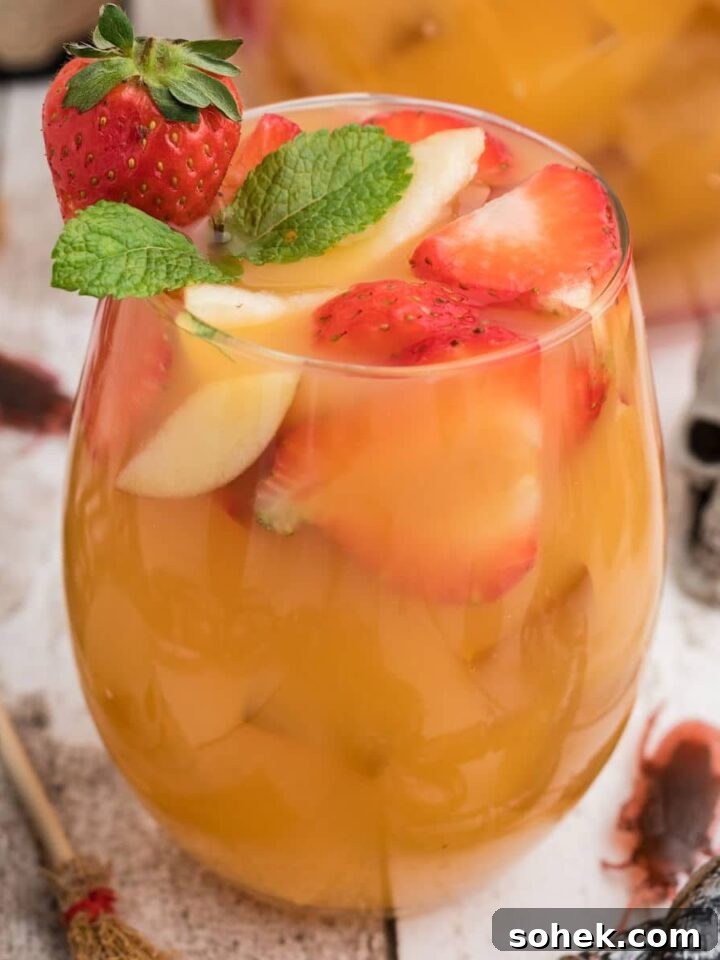 close up of a glass of jungle juice with a skeleton in the background.