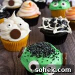 close up of halloween cupcakes, with ghost cupcake, frankenstein cupcake, spiderweb cupcake
