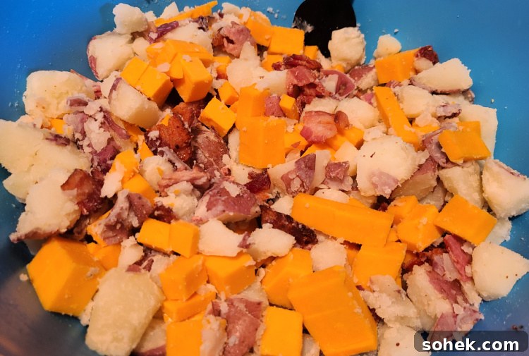 Red Potatoes in bowl with cheese and cooked bacon