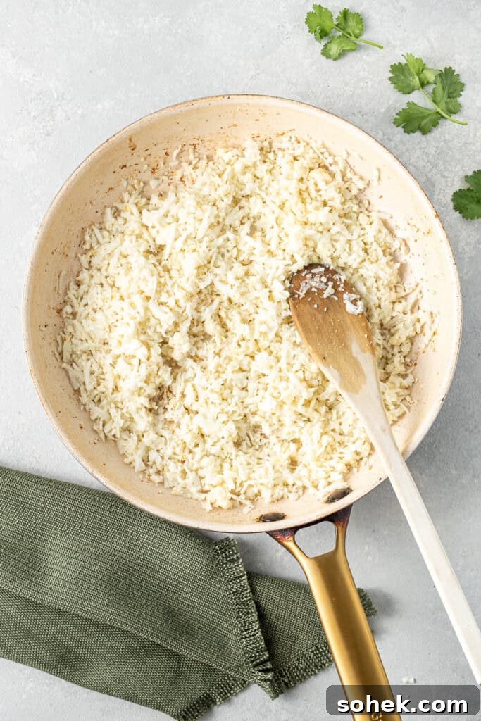 Cooking cauliflower rice in a frying pan.