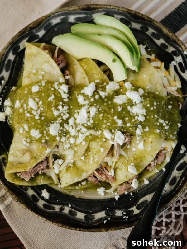 black and tan plate filled with 3 pulled pork enchiladas verdes.