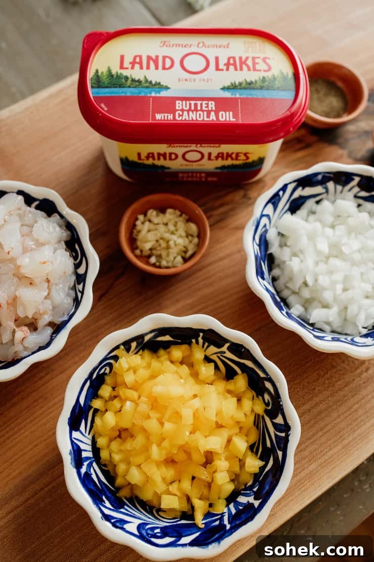 tub of butter with canola oil, bowl of chopped shrimp, bowl of chopped onion, diced garlic. 