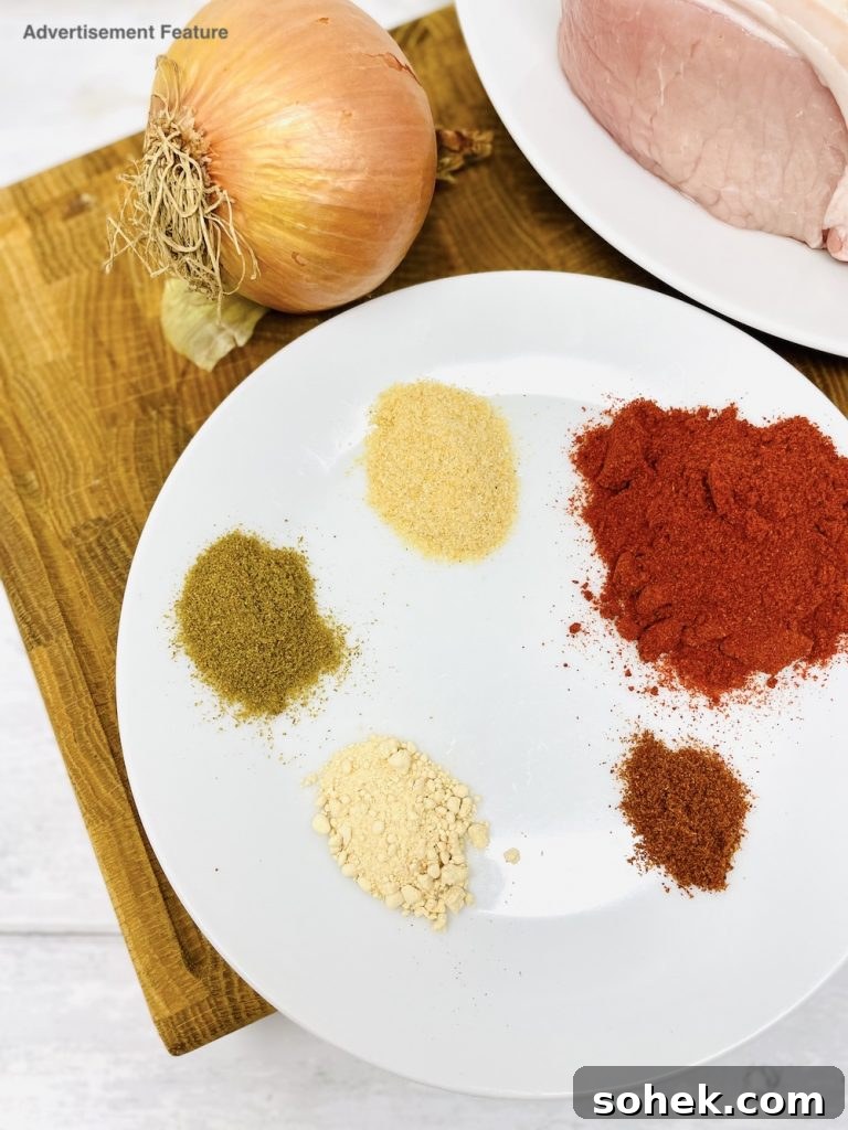 Smoky Pulled Pork for Bonfire Night Recipes 2 Smoky pulled pork ingredients - boneless pork shoulder, a brown onion, plate of spices - smoked paprika, garlic powder, onion powder, cayenne pepper and ground cumin