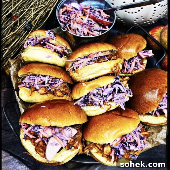 Homemade smoky pulled pork with homemade coleslaw stuffed into brioche rolls on a serving tray ready to grab and go