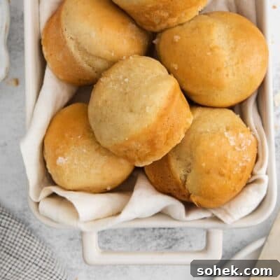Soft Gluten-Free Dinner Rolls Recipe for Tender, Fluffy Buns 10 dinner rolls in a baking dish with a tea towel.