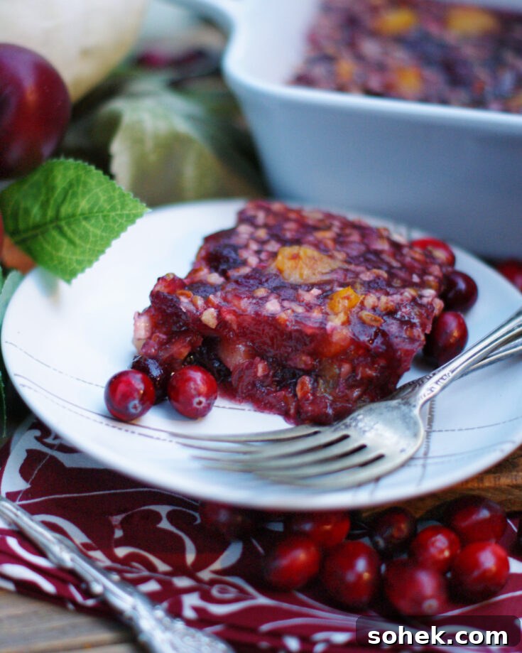 A slice of old fashioned cranberry jello salad garnished with fresh cranberries.