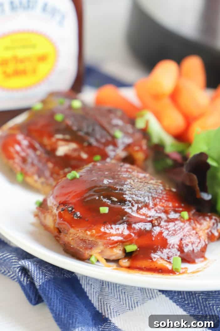 Sticky Slow Cooker BBQ Chicken Thighs Recipe for Tender Meat 5 chicken thighs on a plate with salad