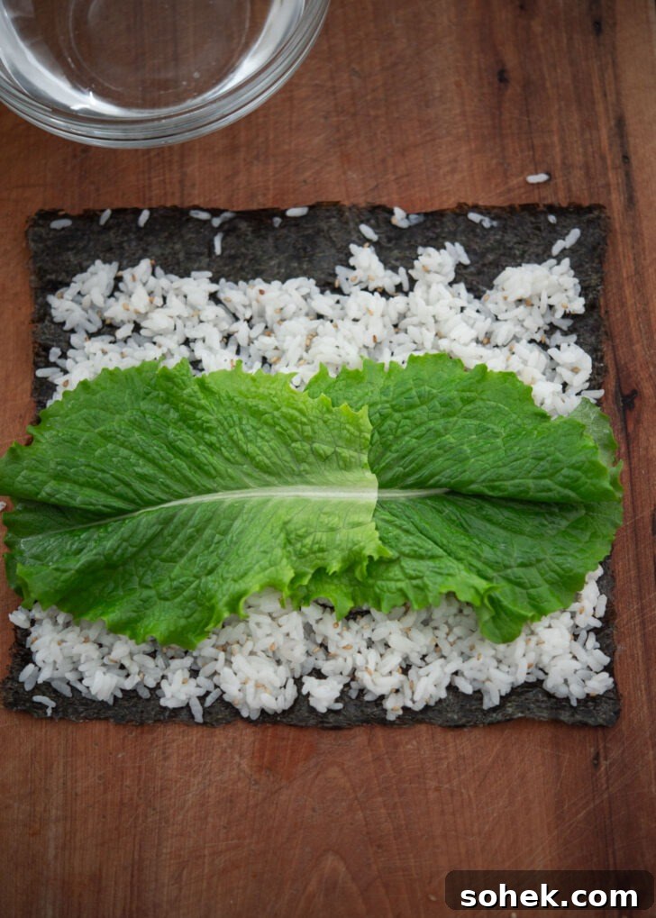 Fresh lettuce leaves added on top of rice and seaweed
