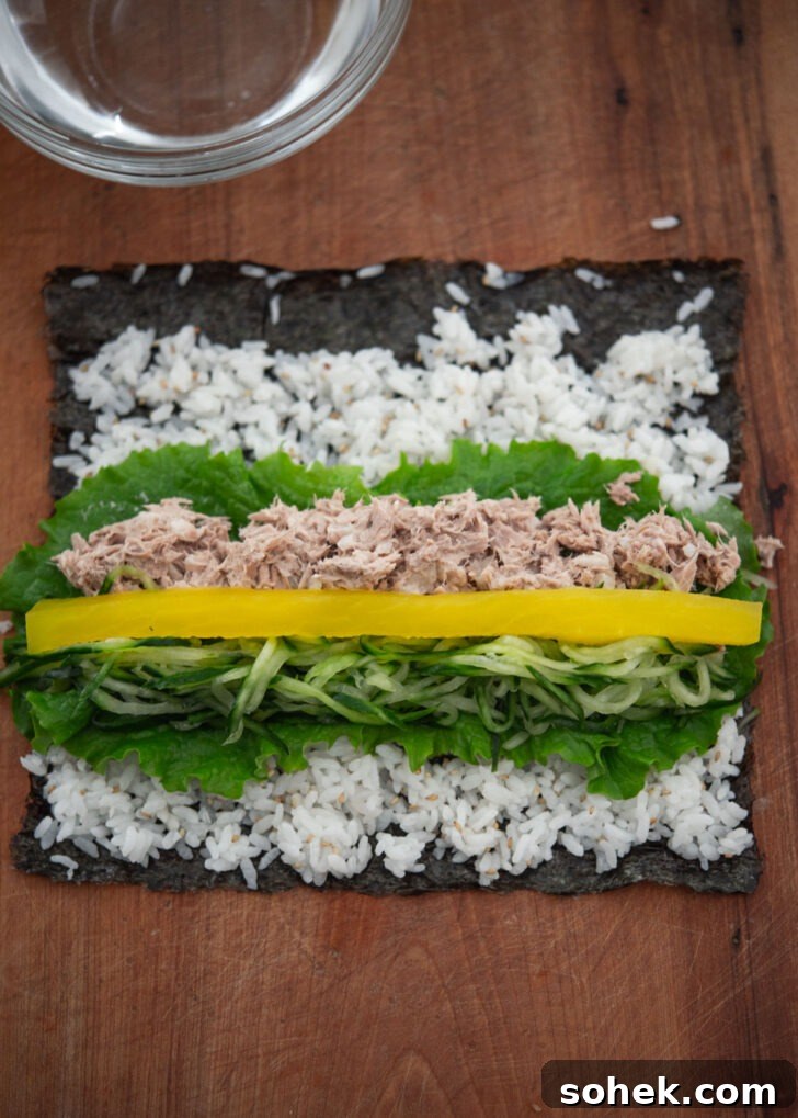 Kimbap filling with tuna, cucumber, and pickled radish placed on lettuce
